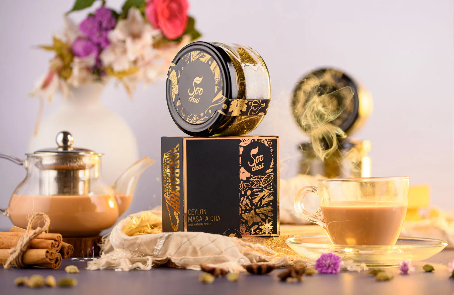 SOO Ceylon Masala Chai gift set — canister, box, teapot and a golden cup of chai with spices and flowers
