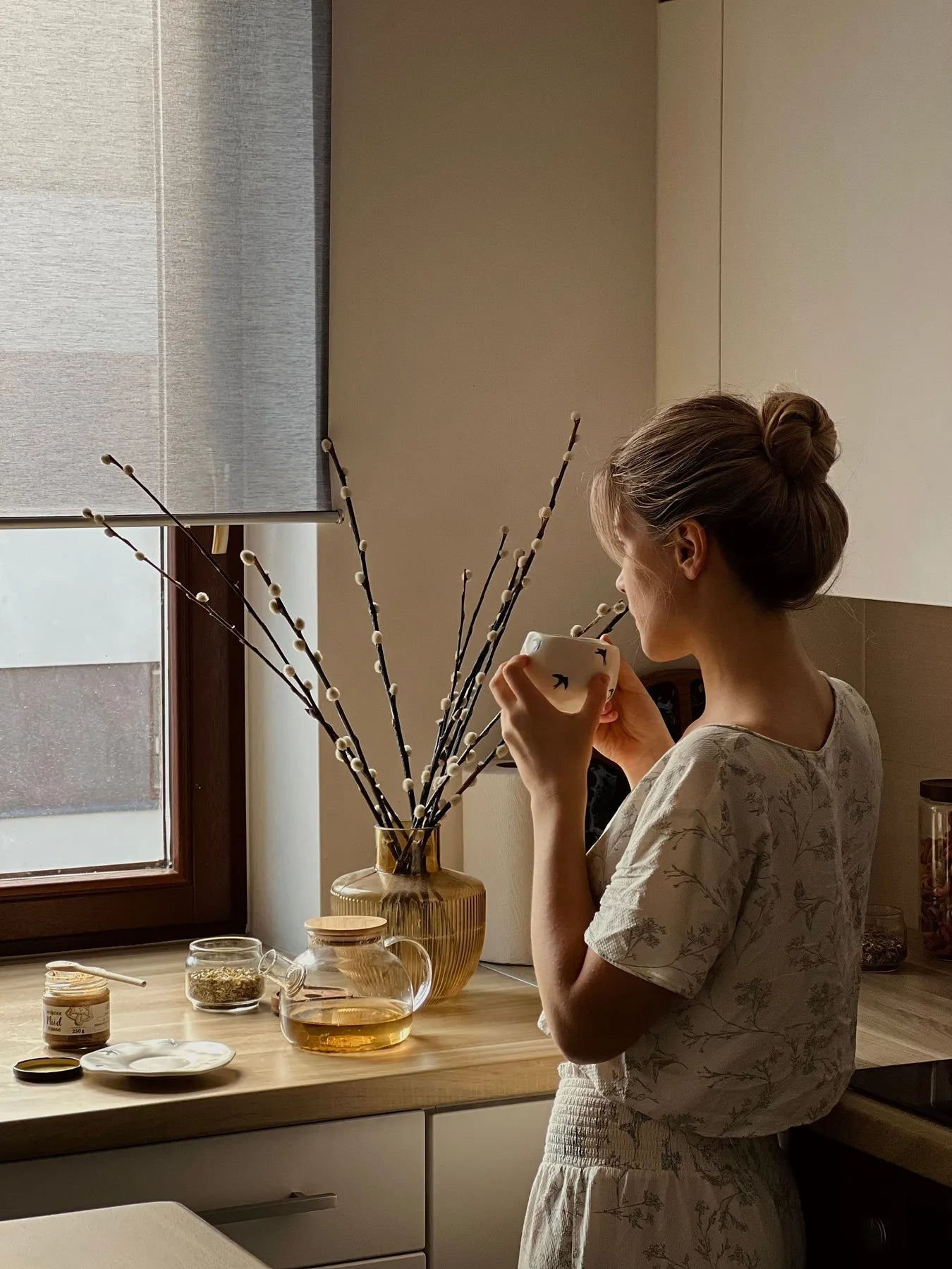 Woman savouring a quiet cup of tea by a sunlit window